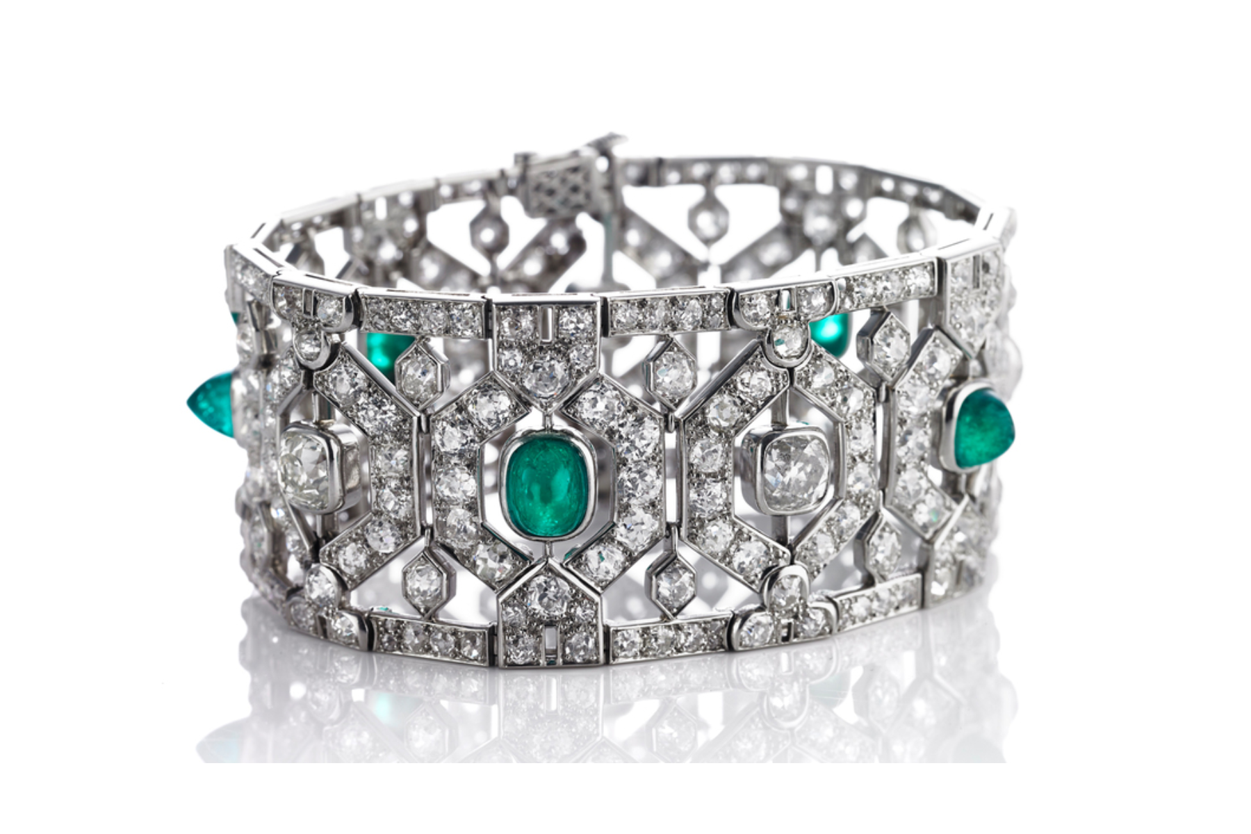 Beehive-shaped form with line framing, five sugarloaf cabochon emeralds and four cushion-shaped old mine-cut diamonds in the center, surrounded by countless rose and old mine-cut diamonds, mounted in platin