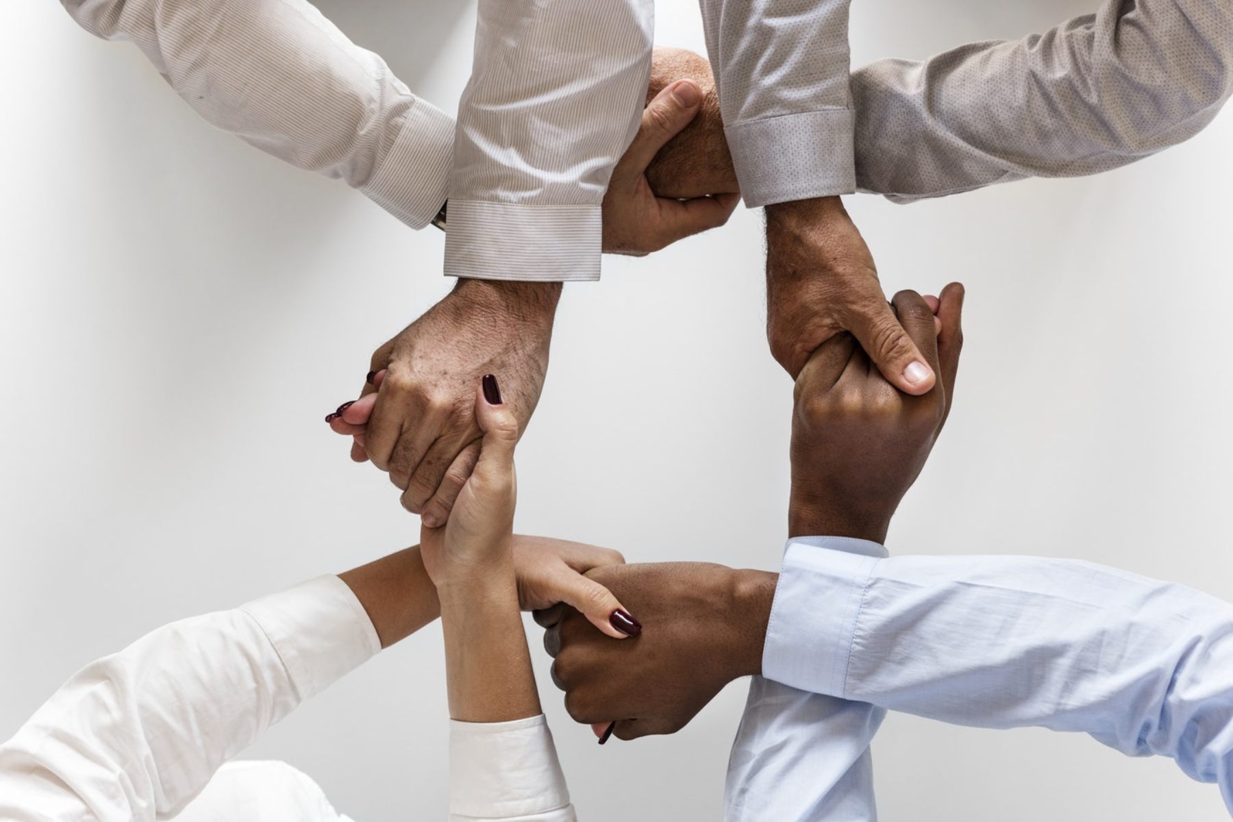 4 people interlocking hands with each other