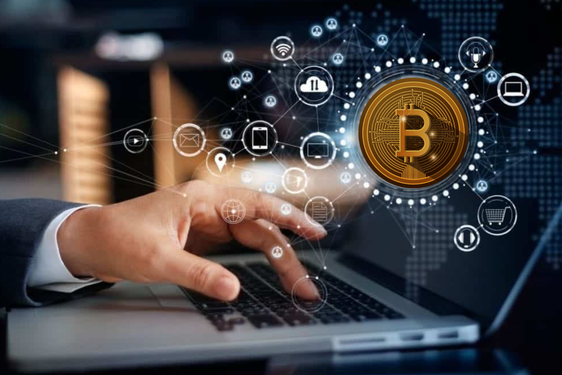 A man sitting in front of a laptop, next to a man is a 3D technology and there is a crypto displayed on it