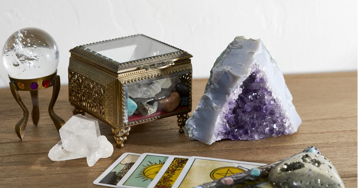 A collection of tarot cards surrounded by various crystals, symbolizing the fusion of gemstone energy and divination