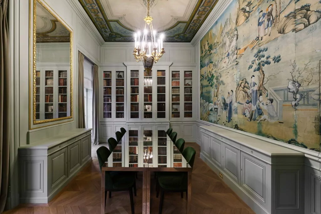 Elegant library dining room with chandelier and mural